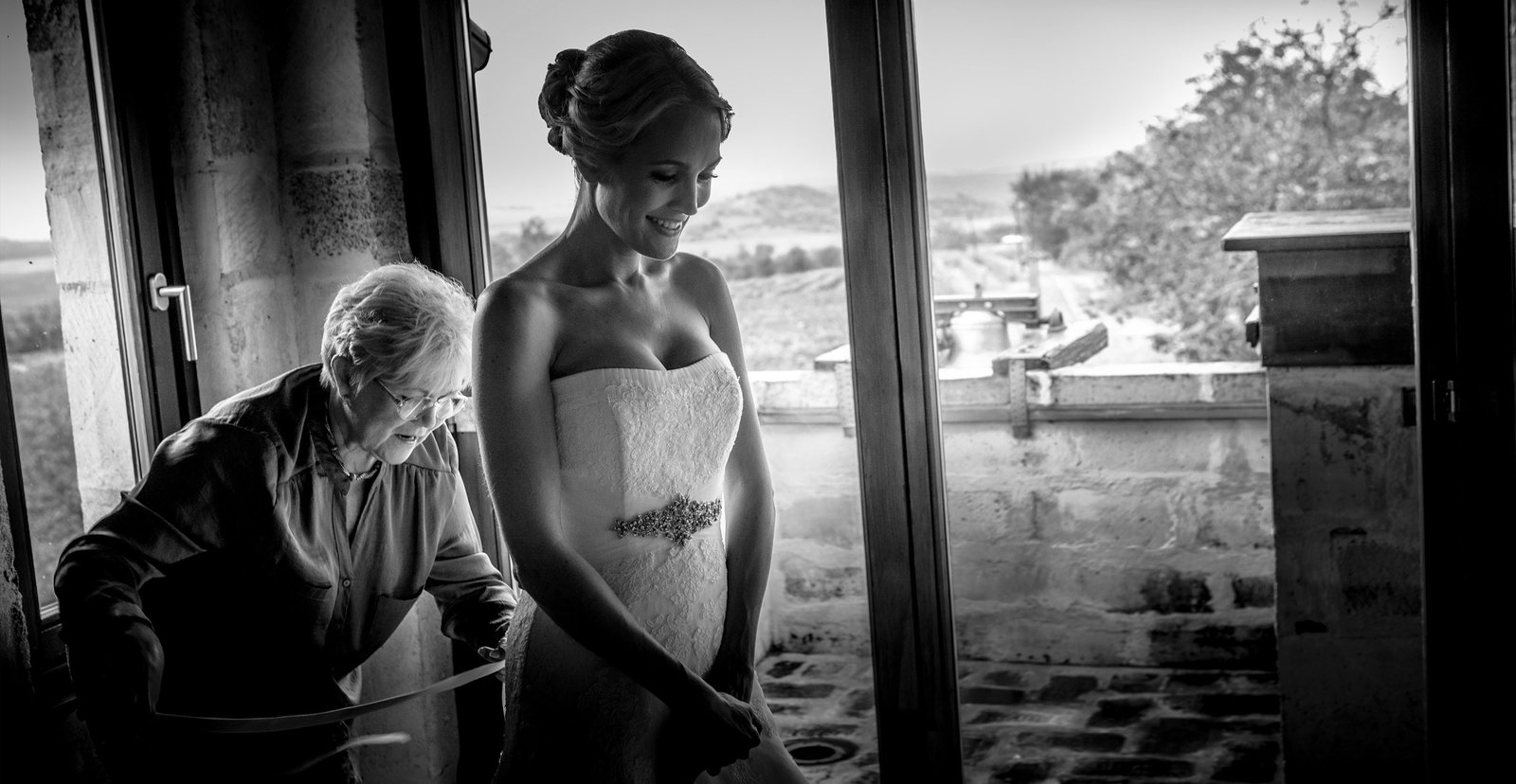 Exciting moments of getting ready: the bride's mother helps her dress.