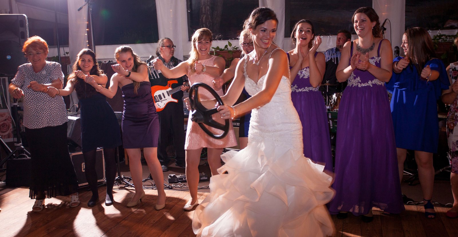 The groom and the bride are dancing and having fun at the party after dinner.