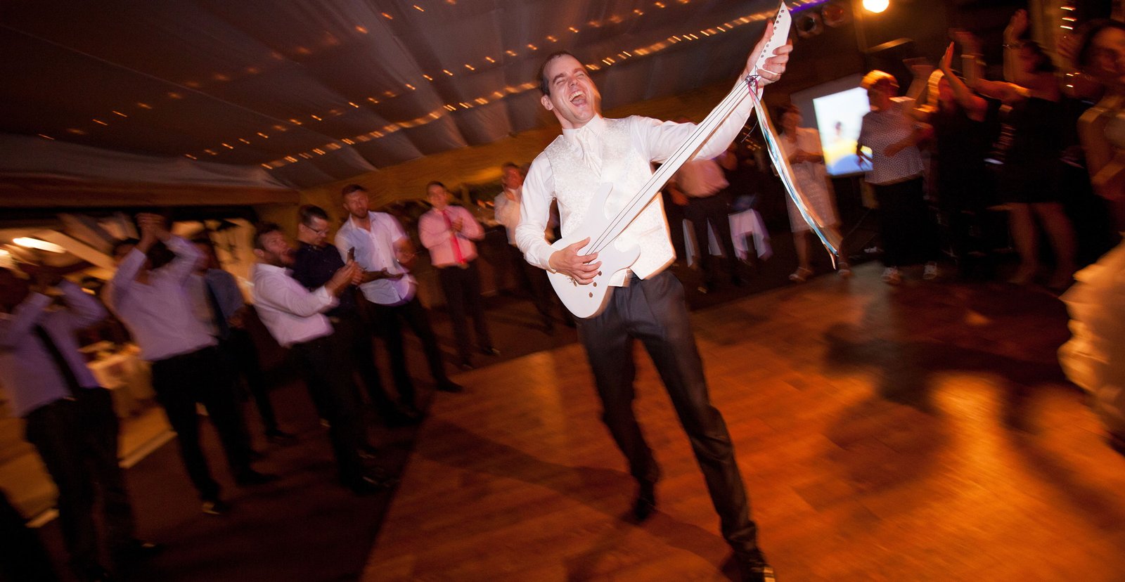 The groom and the bride are dancing and having fun at the party after dinner.