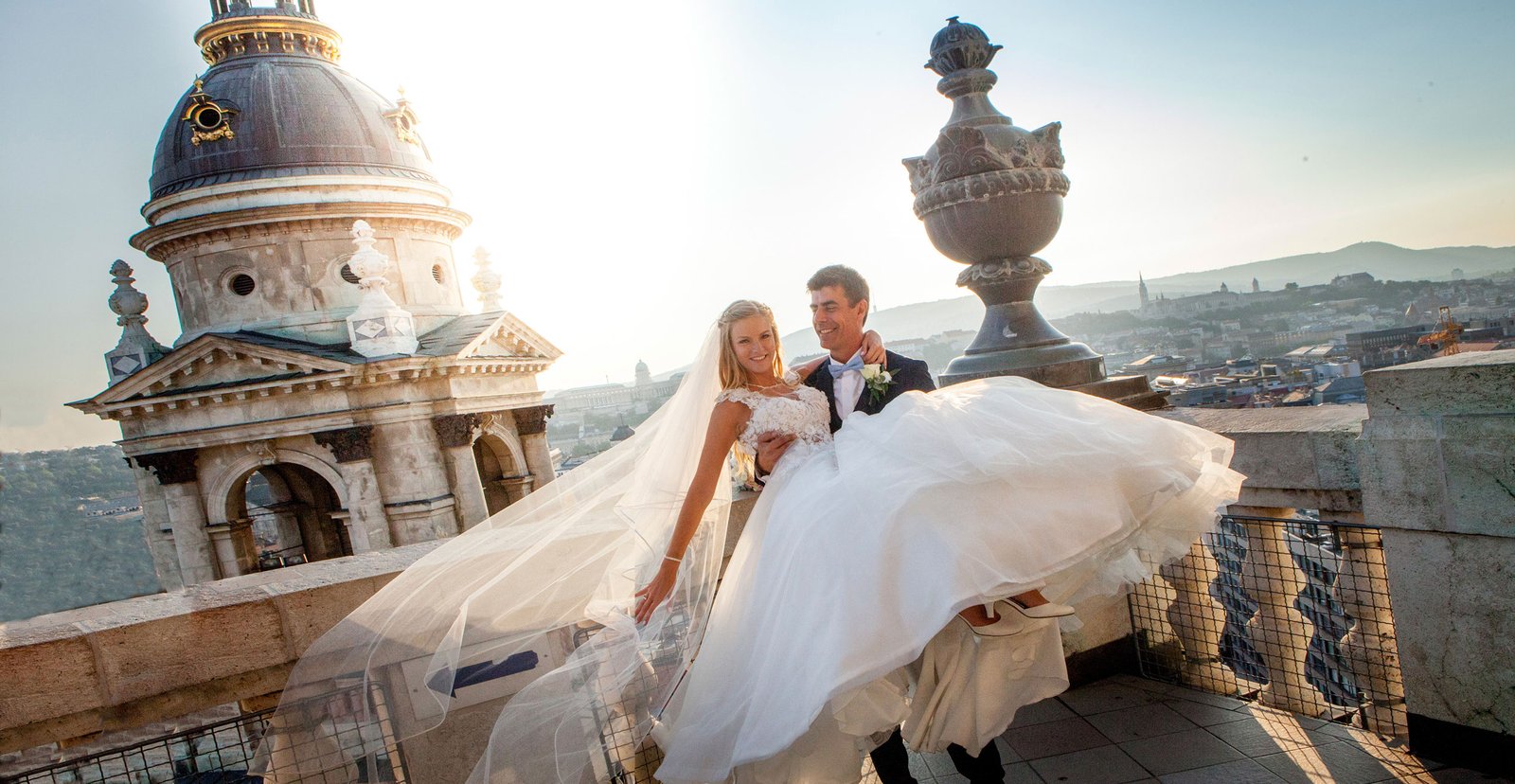 On top of the Basilica, between sky and earth, the groom lifts the bride in a breathtaking wedding moment.